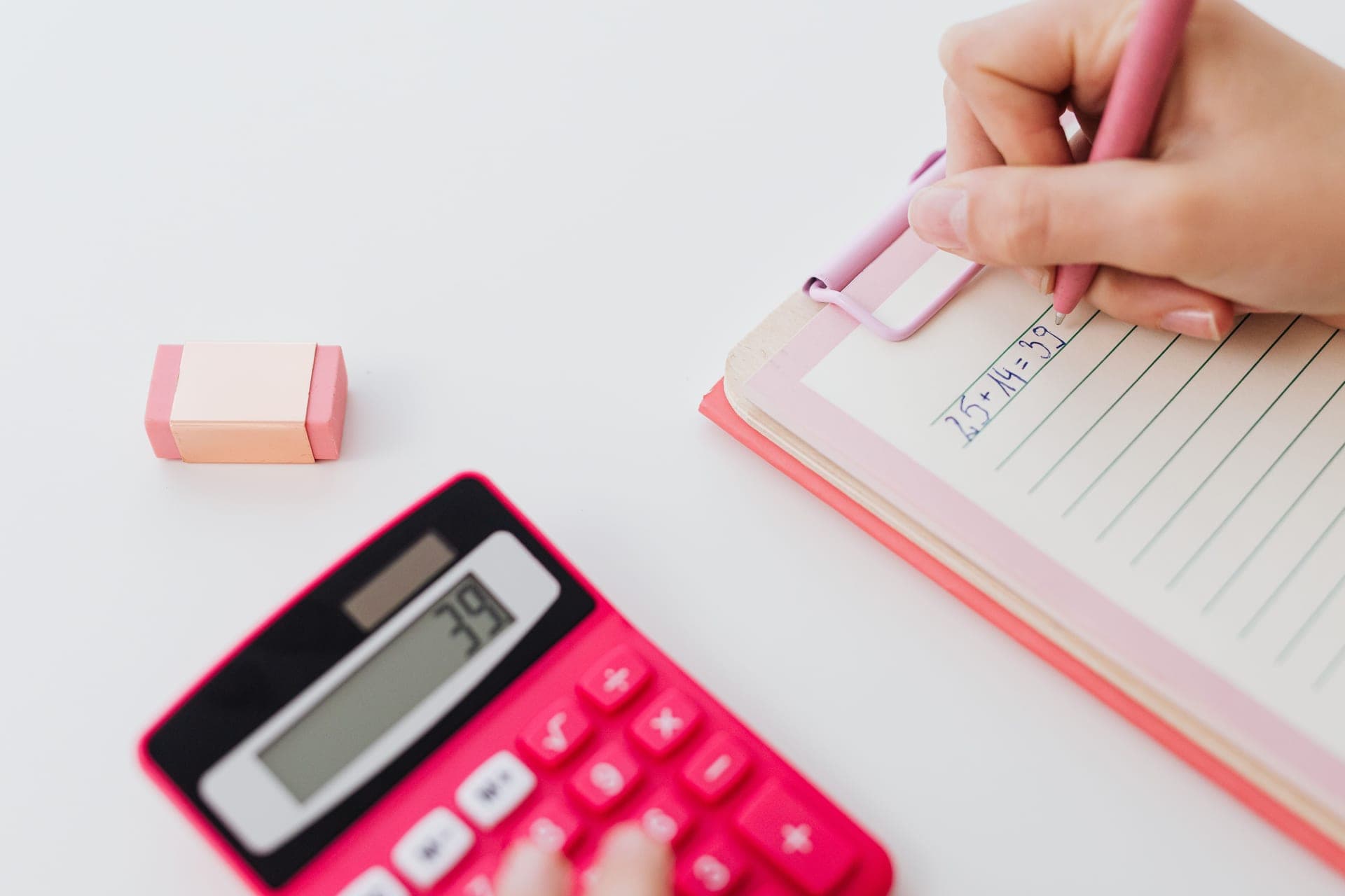 A calculator and notebook on a desk