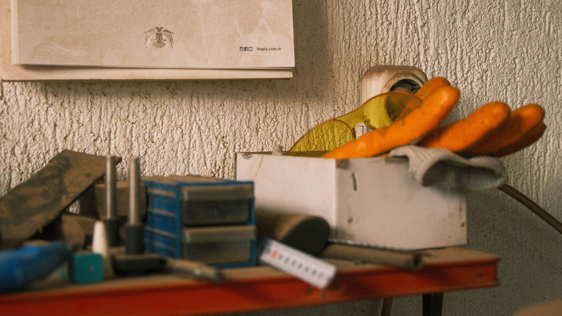 Safety equipment and gloves laid out on a workshop bench